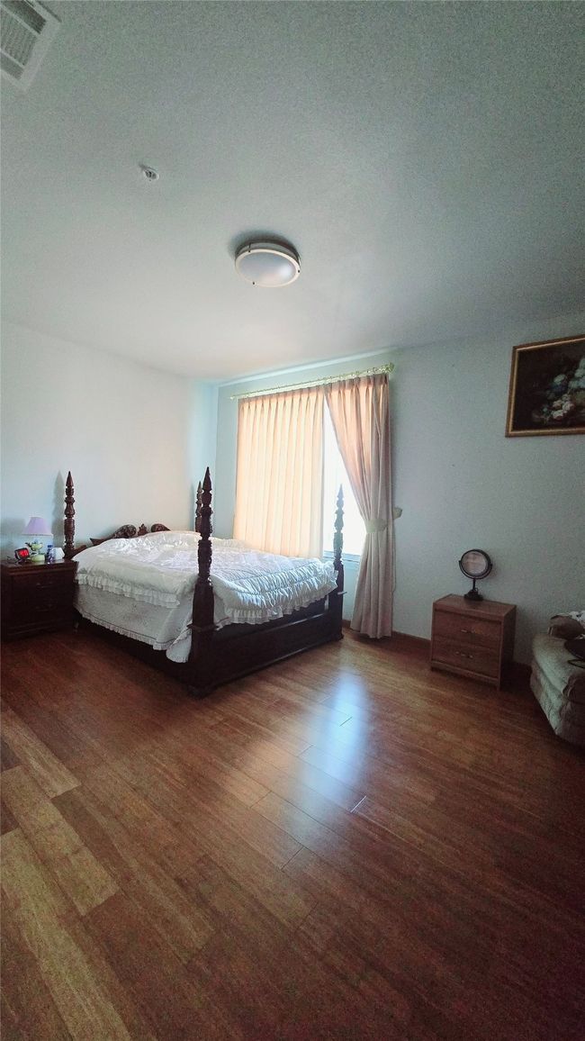 Bedroom with a textured ceiling and wood finished floors | Image 9