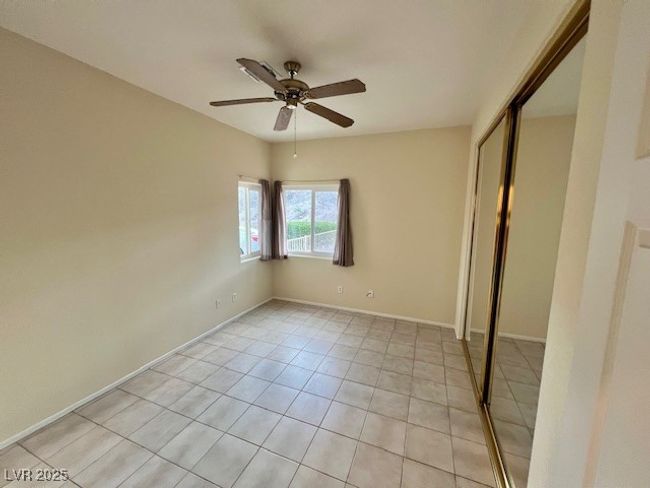 Hallway with visible vents, a textured wall, and light tile patterned floors | Image 25