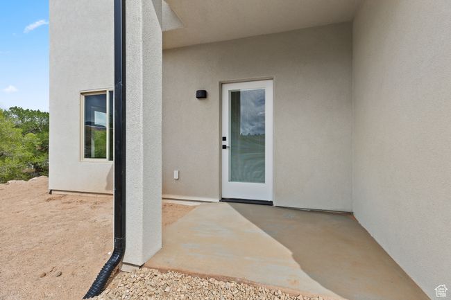 Doorway to property featuring stucco siding and a patio area | Image 14