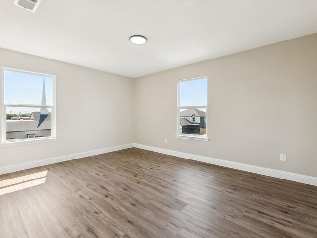 Empty room with baseboards, wood finished floors, visible vents, and plenty of natural light | Image 23