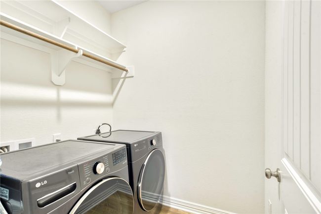 Laundry room with washer and dryer and wood finished floors | Image 21