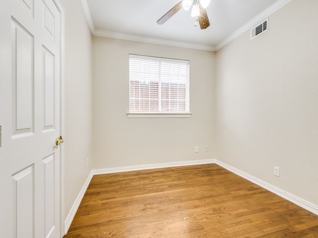 Third downstairs bedroom with ceiling fan, hardwood floors, and crown molding. | Image 20