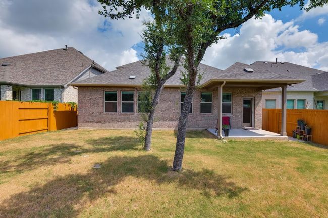 Back of house featuring brick siding, a patio area, and a shingled roof | Image 35
