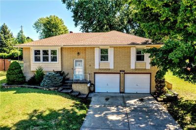 Split foyer home featuring a garage and a front lawn | Image 1