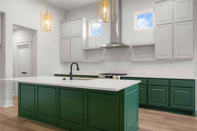 Kitchen featuring range hood, a healthy amount of sunlight, sink, and white cabinets | Image 11