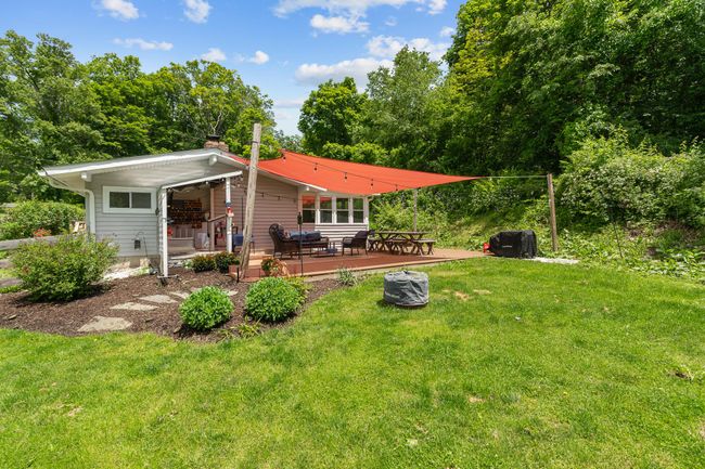 Rear view of property with a yard, a wooden deck, and a chimney | Image 9