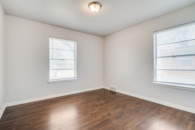 Empty room with baseboards, dark wood-style floors, and a wealth of natural light | Image 19