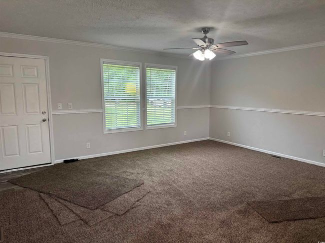 Unfurnished room with ceiling fan, ornamental molding, a textured ceiling, and carpet | Image 13