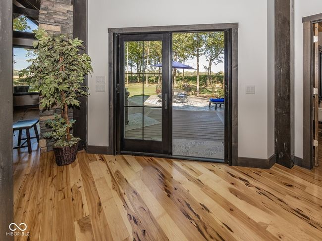 doorway featuring baseboards and wood finished floors | Image 38