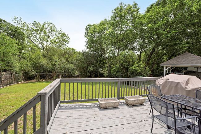 Wooden terrace with a grill, a fenced backyard, and a lawn | Image 31