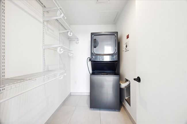 Laundry room with estacked washer and dryer and light tile patterned floors | Image 14