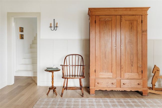 Living area with a wainscoted wall, wood finished floors, and stairway | Image 4