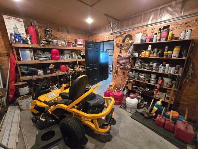 Back room-with overhead door with shelving perfect for lawn mowers | Image 59