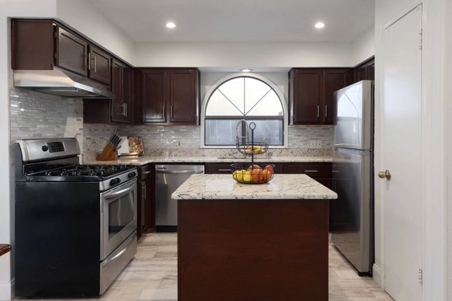 Stainless appliances include a gas range, range hood and dishwasher | Image 9