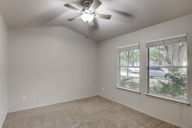 Carpeted empty room featuring vaulted ceiling, ceiling fan, and baseboards | Image 24