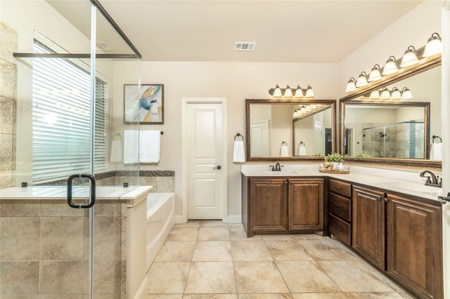 Bathroom featuring a bath, a stall shower, and double vanity | Image 17
