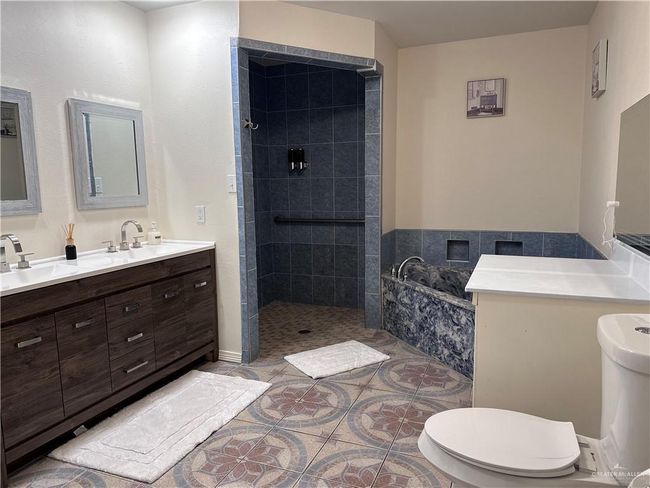 Full bathroom featuring toilet, vanity, tile patterned floors, and plus walk in shower | Image 13