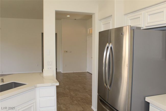 Kitchen featuring freestanding refrigerator, white cabinetry, and a sink | Image 13