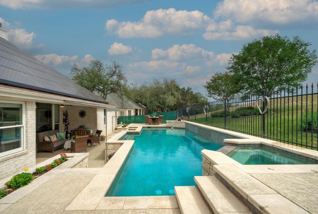 View of swimming pool featuring a patio, a fenced in pool, a fenced backyard, an in ground hot tub, and an outdoor hangout area | Image 33