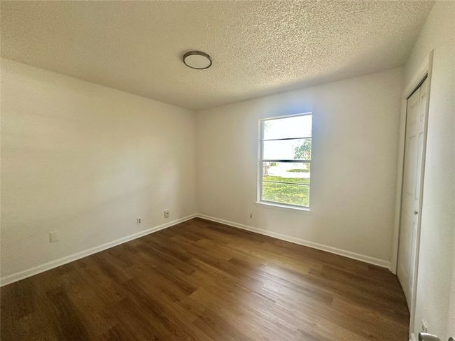 Spare room featuring dark wood finished floors and a textured ceiling | Image 13