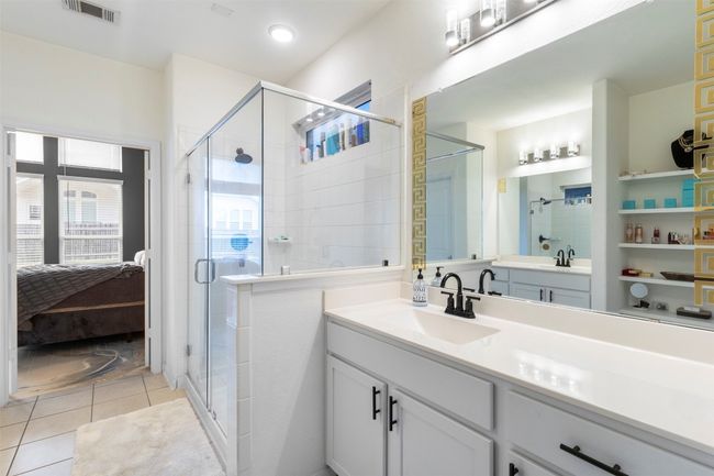 Full bath featuring connected bathroom, vanity, a shower stall, and tile flooring | Image 17
