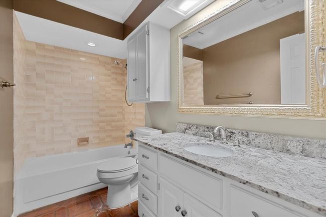 Full bathroom featuring vanity, tile patterned floors, ornamental molding, tiled shower / bath combo, and toilet | Image 30