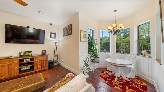 Living room with recessed lighting, baseboards, a chandelier, dark wood-style floors, and wainscoting | Image 14