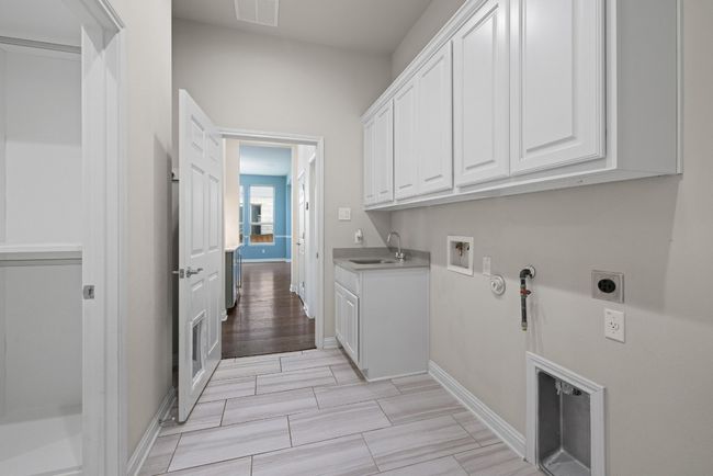 Laundry area featuring electric dryer hookup, cabinet space, hookup for a gas dryer, and washer hookup | Image 35