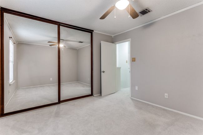 Unfurnished bedroom featuring carpet flooring, ornamental molding, a ceiling fan, and a closet | Image 18