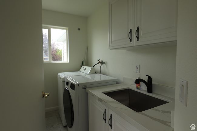 Washroom with cabinet space and washing machine and clothes dryer | Image 16