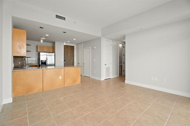 A view toward the kitchen and front door from the living room. | Image 7