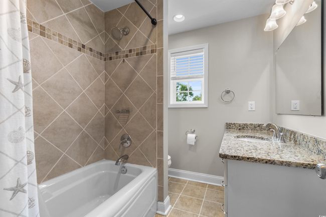 Bathroom with baseboards, vanity, shower / bathtub combination with curtain, toilet, and tile patterned floors | Image 27