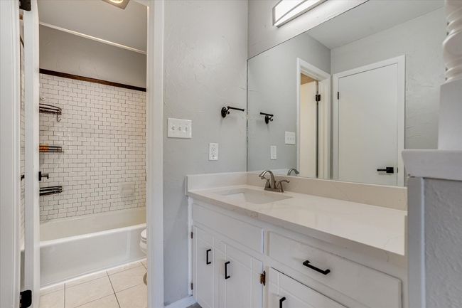 Bathroom featuring vanity, toilet, tile patterned flooring, and shower / washtub combination | Image 8