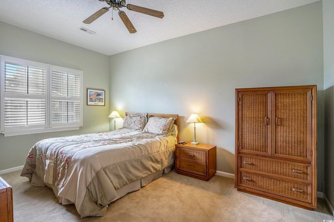 Bedroom featuring carpet, baseboards, ceiling fan, and a textured ceiling | Image 8