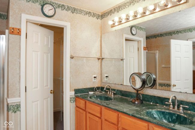 bathroom with double vanity, a shower with door, and a sink | Image 20