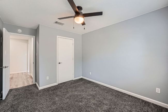 Unfurnished bedroom featuring baseboards, ceiling fan, carpet flooring, and visible vents | Image 19