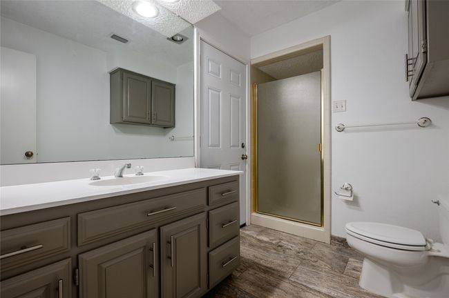 Bathroom featuring toilet, a shower stall, visible vents, and vanity | Image 11
