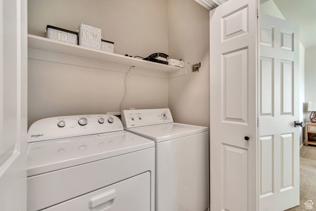 Laundry room featuring washing machine and clothes dryer, laundry area, and light colored carpet | Image 15