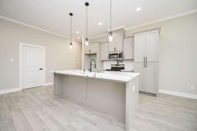 Beautiful Island Kitchen With Quartz Countertops and Tiered Lighting. This Area Is Great For Making Those Special Dinners & Gives You Lots Of Room To Do So. There Is Also Space Underneath The Front Side Of The Island Kitchen For A Tucked In Seating Area | Image 9
