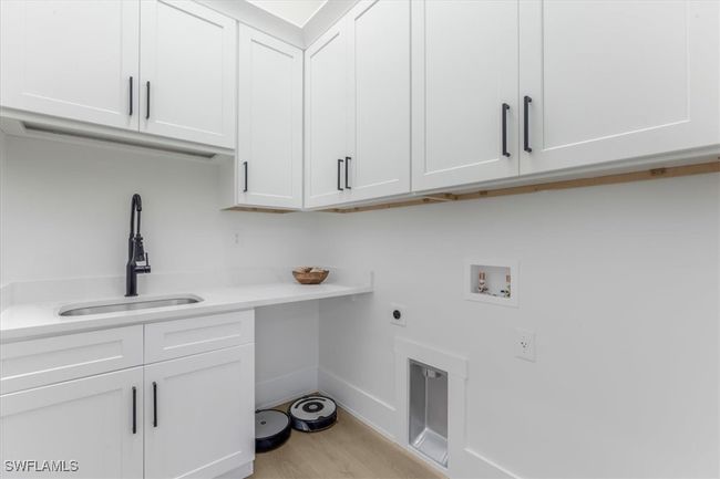 Washroom featuring washer hookup, electric dryer hookup, cabinet space, and light wood-style floors | Image 8