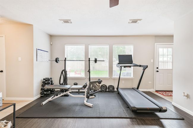 At the back of the living room, the current owner has a gym overlooking the back yard. What would you do with this space? | Image 10
