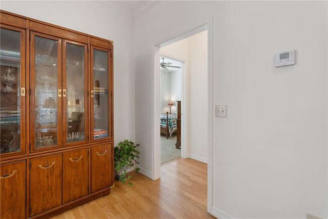 Corridor featuring light wood-style floors, baseboards, and crown molding | Image 35