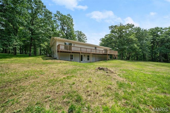 Rear view of property featuring a wooden deck and a lawn | Image 51
