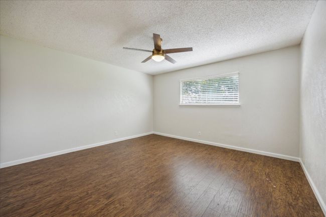 Spare room with ceiling fan, a textured ceiling, and dark wood finished floors | Image 23