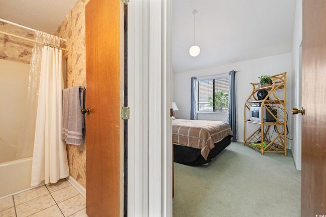 Bedroom with tile patterned flooring and lofted ceiling | Image 11