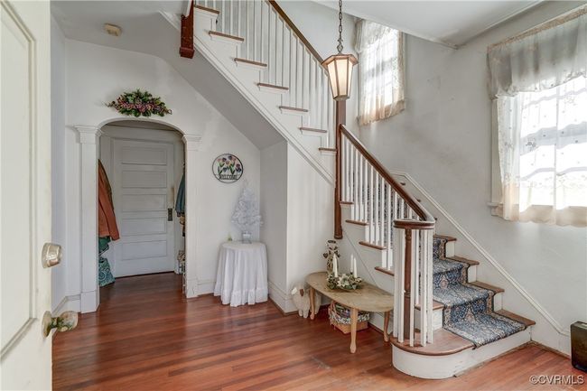Stairs with baseboards, arched walkways, and wood finished floors | Image 8