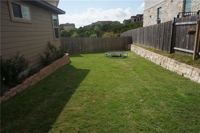 Fenced backyard featuring a trampoline | Image 12