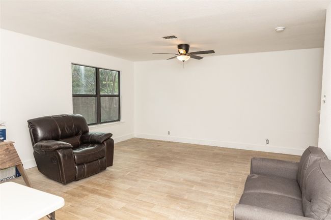 Living area with ceiling fan and light wood finished floors | Image 4