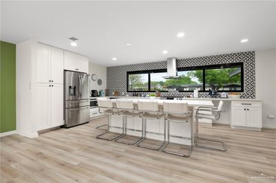 Kitchen featuring plenty of natural light, white cabinetry, stainless steel fridge, and light hardwood / wood-style flooring | Image 3