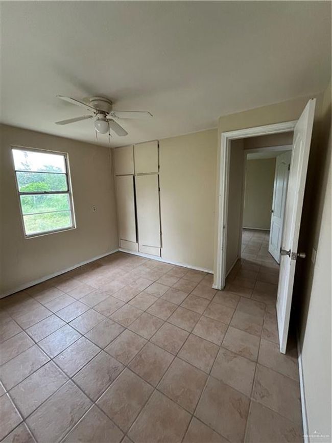 Unfurnished room with light tile patterned floors, a ceiling fan, and baseboards | Image 11